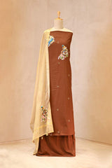 Brown traditional outfit with floral embroidery on a mannequin against a beige background