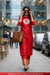 Woman in a red outfit with a brown bag walking on a city street.
