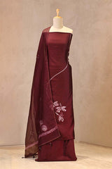 tie and dye Matsya (fish) motifs with Aari embroidery on a maroon Chiniya silk unstitched suit set, paired with a tie-dye scalloped organza dupatta.