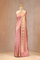 Peach saree with a subtle pattern on a mannequin against a plain background