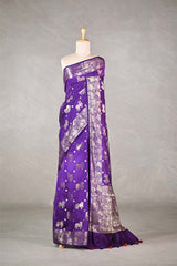 Purple saree with silver Pichwai cow patterns draped on a mannequin against a gray background
