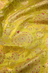 Close-up of green fabric with intricate gold embroidery and red accents