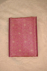 Decorative maroon fabric with intricate patterns on a beige background