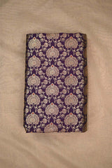 A purple wine silk fabric with gold zari woven floral pattern with red accents on beige background