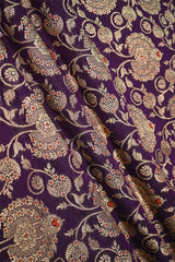 Close-up of a purple wine silk fabric with gold zari woven floral pattern with red accents