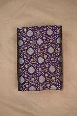 A purple wine silk fabric with gold and silver zari woven floral pattern on beige background