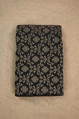 A black silk fabric with beige floral pattern woven with antique zari on beige background