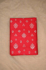 red raw silk fabric with gold and green floral patterns on beige background