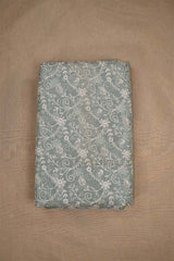 An embroidered grey fabric with floral patterns on beige background