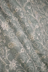 Close-up of embroidered grey fabric with floral patterns