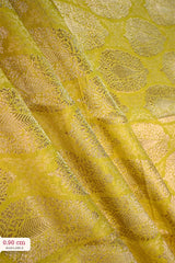 Close-up of a yellow banarasi silk fabric with intricate floral brocade pattern