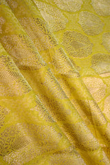 Close-up of a yellow banarasi silk fabric with intricate floral brocade pattern