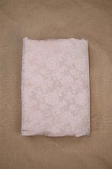 Close-up of an off white banarasi silk fabric with tanchoi floral woven pattern on beige background