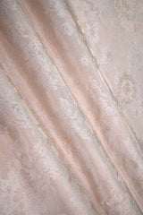 Close-up of an off white banarasi silk fabric with tanchoi floral woven pattern