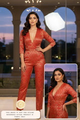 Woman wearing a red crop top and Pant made with red Banarasi silk fabric with a close-up inset, standing in front of a window.