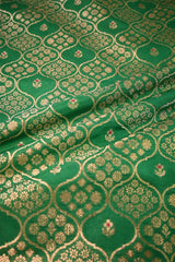 Close-up of green fabric with gold floral patterns