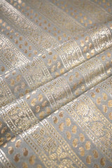 Close-up of metallic gold fabric pattern on gray background