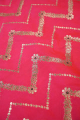 Close-up of pink fabric with gold zig-zag floral stripe patterns