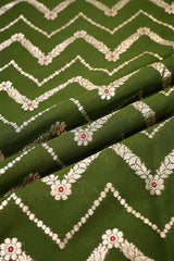 Green fabric with white zigzag pattern and red floral details
