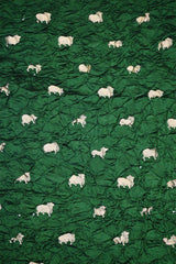 Close-up of Bottle Green Bandhani fabric with Pichwai motifs.