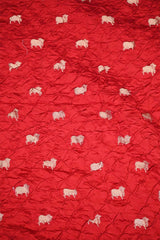 Close-up of Red Bandhani fabric with Pichwai motifs.