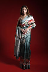 A woman wearing a floral printed Banarasi saree giving a perfect party look against a red background