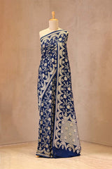 Blue saree with white patterns on a mannequin against a beige background