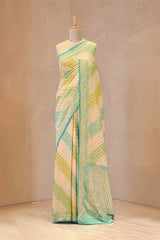 green and beige saree pattern on a mannequin against a plain background