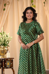 A woman in a green traditional kurti co-ord set, standing in a decorated indoor setting.