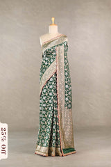 Green floral saree with a textured border on a mannequin against a neutral background