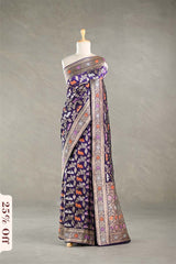 Red Banarasi silk saree with light gold intricate Pichwai woven patterns draped on a mannequin against a gray background