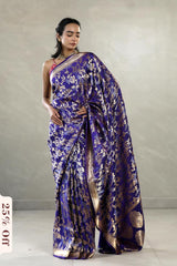 Woman wearing a blue floral saree with a plain background