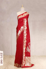 Red saree with white embroidery on a mannequin against a plain background