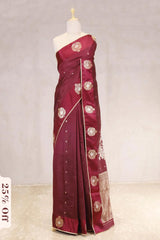 Maroon saree with gold embroidery on a mannequin against a light background