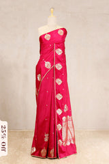 Red saree with gold embroidery on a mannequin against a beige background