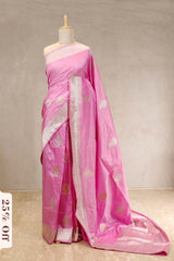 Pink saree with white blouse on a mannequin against a plain background