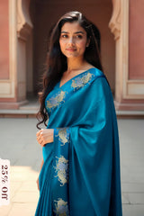 Woman wearing a blue saree with floral patterns in an outdoor setting