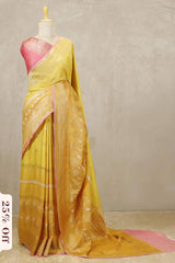 Yellow saree with pink blouse on a mannequin against a plain background