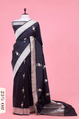 Black saree with white patterns on a mannequin against a pink background