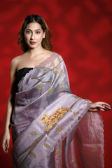 A woman wearing a lilac purple party wear saree with floral shikargah patterns on a red background