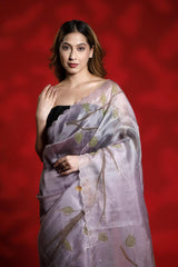 A woman wearing a lilac purple party wear saree with floral shikargah patterns on a red background