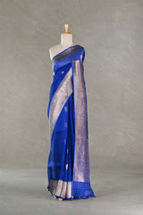 Blue saree with gold border on a mannequin against a gray background