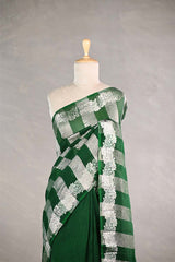 Green and white checkered organza silk tissue saree draped on a mannequin against a gray background