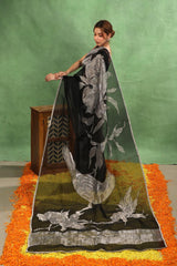 Women wearing Black Organza Silk Saree showing half and half design with silver stripes and flora fauna applique work.