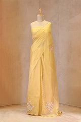 Yellow saree with floral embroidery on a mannequin against a plain background
