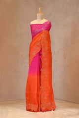 Mannequin wearing a pink and orange saree with intricate patterns against a plain background