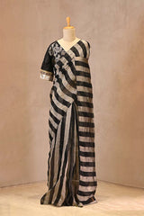Black organza silk saree with silver zari stripes and tassel pallu with raw silk blouse