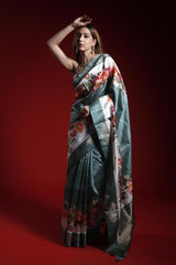 A woman wearing a floral printed Banarasi saree giving a perfect party look against a red background