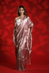 A woman wearing a pink party wear saree with a floral blouse against a red background