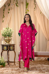 A woman in a traditional pink kaftan co-ord set, standing in a decorated indoor setting.